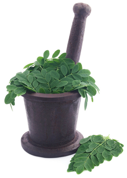 Edible moringa leaves in a vintage mortar  - Photo, Image