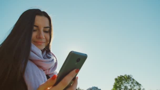 Όμορφη γυναίκα με smartphone στέκεται - Πλάνα, βίντεο