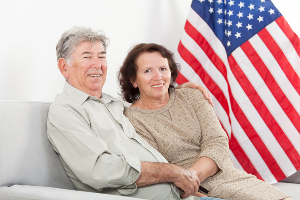 Heureux couple de personnes âgées assis devant le drapeau américain
 - Photo, image
