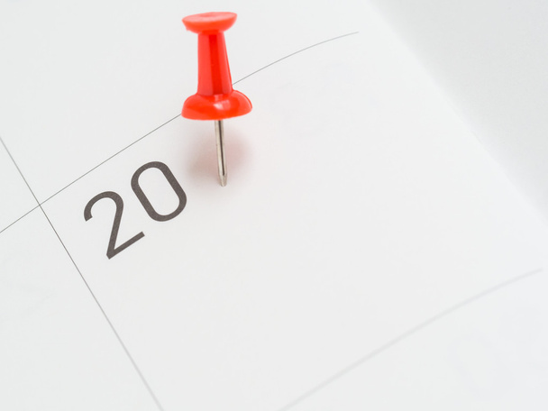 Red pin on 20 date on calendar paper - Photo, Image