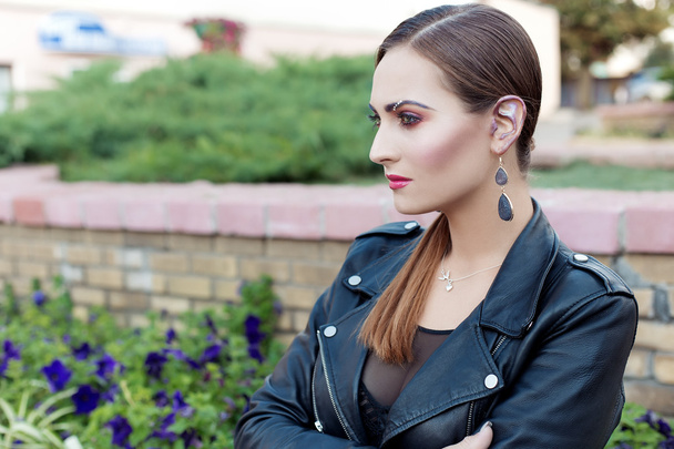 beautiful shot of a girl with bright trendy makeup in black leather skirt in the style of glam rock - Fotó, kép