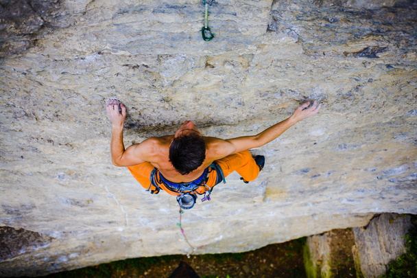Male sports and climbs on the rock. - Photo, Image