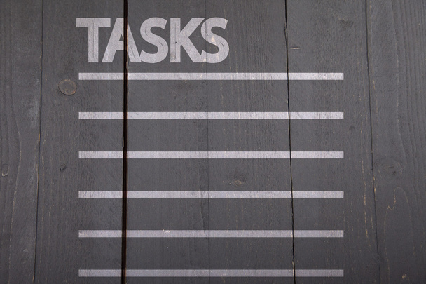 Tasks list on black wooden background - 写真・画像