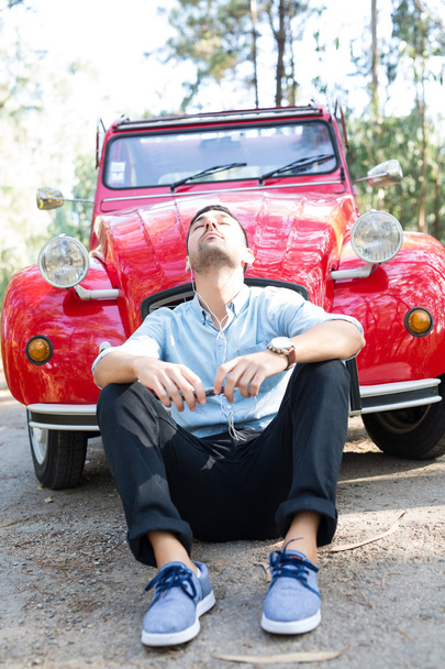 Jonge man rust aan auto - Foto, afbeelding