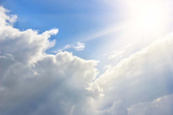 Epische blauwe hemel met witte pluizige wolken en zon. Zonnige dag - Foto, afbeelding