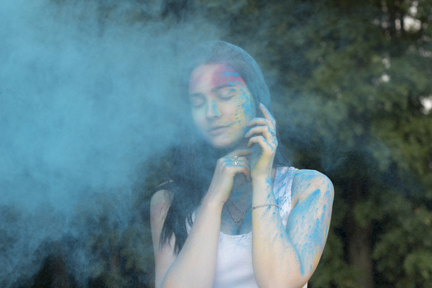 Modèle Brunette posant avec de la poudre de couleur tombant sur elle
 - Photo, image