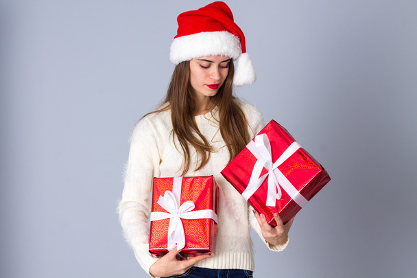 Γυναίκα με κόκκινο καπέλο Χριστουγέννων κρατώντας δώρα - Φωτογραφία, εικόνα