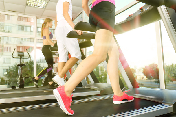 Jugendliche laufen auf Laufbändern im Fitnessstudio, Nahsicht - Foto, Bild