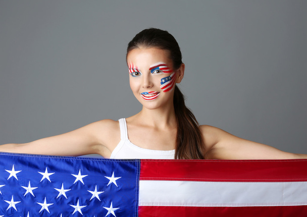 Girl with USA makeup and flag on grey background - Valokuva, kuva