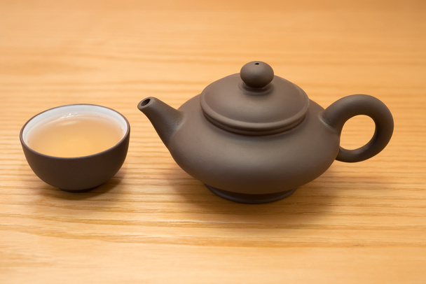 side view cup of tea and teapot on wood table - 写真・画像
