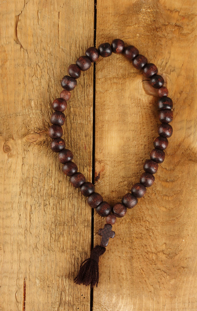 the Wooden rosary beads on wooden background close-up - Φωτογραφία, εικόνα