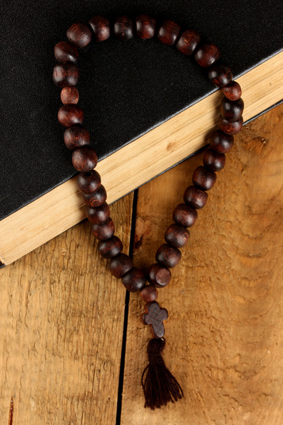 the Wooden rosary beads and holy bible on wooden background close-up - Photo, image