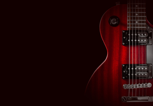Une partie de la guitare électrique rouge sur fond noir. Un lieu d'écriture du texte
. - Photo, image