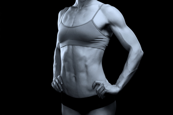 Corpo feminino muscular contra fundo preto
 - Foto, Imagem