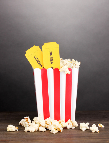 popcorn with tickets on wooden table on grey background - Foto, imagen