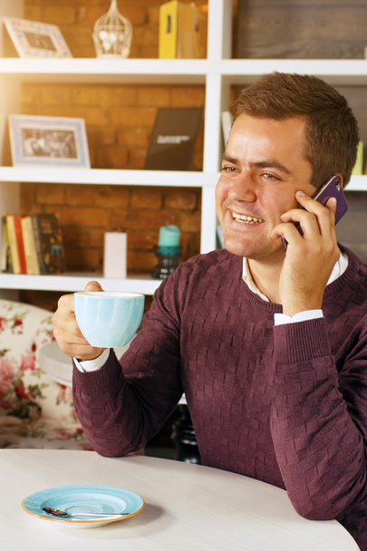 Homem bebendo café e falando ao telefone
 - Foto, Imagem
