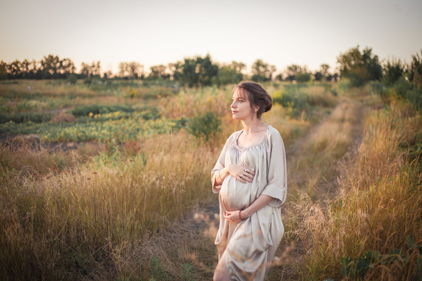 Πορτρέτο της εγκύου γυναίκας στο φως του ηλιοβασιλέματος - Φωτογραφία, εικόνα