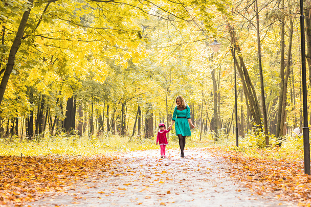 Šťastné matky a dítěte dcera drží ruce v létě nebo podzimní den. - Fotografie, Obrázek