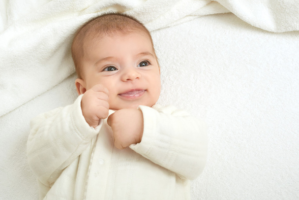 portrait de bébé allongé sur une serviette blanche dans le lit, ton jaune
 - Photo, image