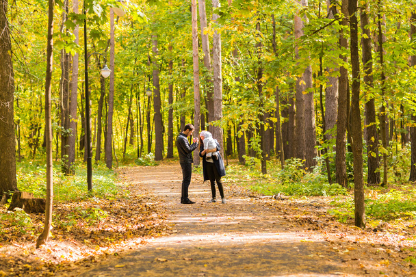 Joyeux jeune famille marchant sur la route à l'extérieur en automne nature
. - Photo, image