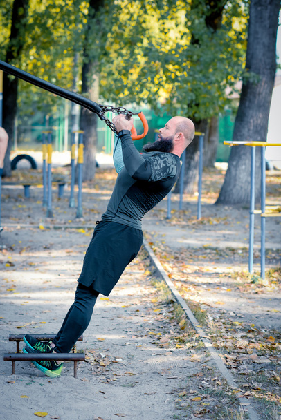 Musculoso barbudo hombre entrenamiento con correas
 - Foto, imagen