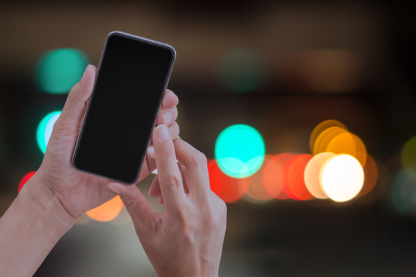 Mano e touch screen smart phone su astratto bokeh indietro
 - Foto, immagini