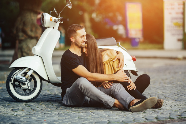 Cute couple with their scooter in the city - Fotó, kép