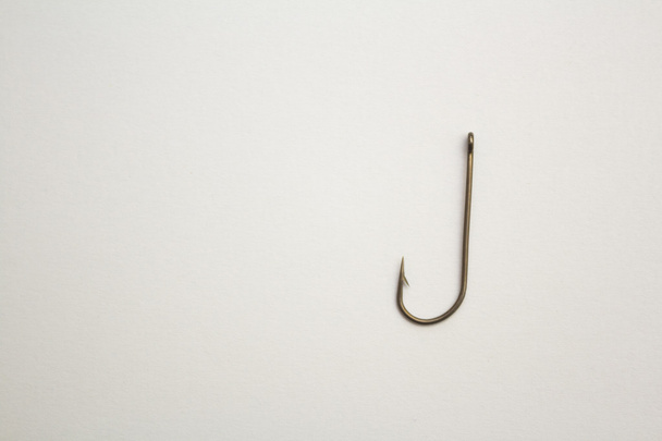 Рыболовный крючок на белом бумажном фоне
 - Фото, изображение