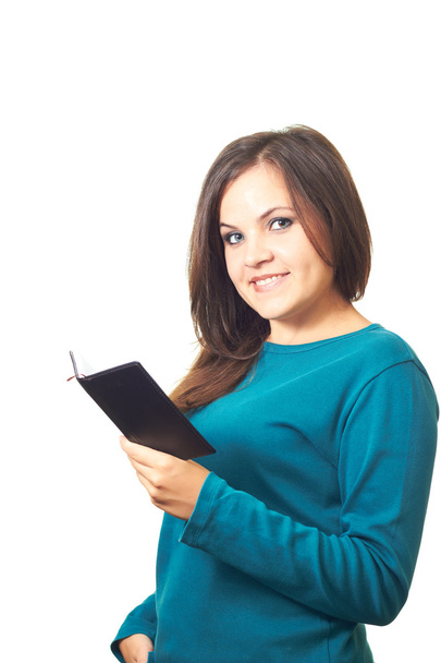 Attractive smiling girl in a blue shirt holding a notebook in he - Foto, Bild