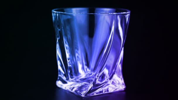 Whiskey wordt gegoten in een glas op zwarte achtergrond - Video