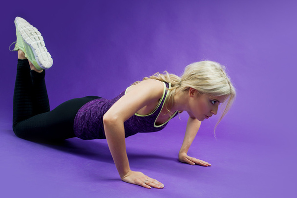 Young Woman Doing Push-Ups workout fitness in studio - Foto, afbeelding