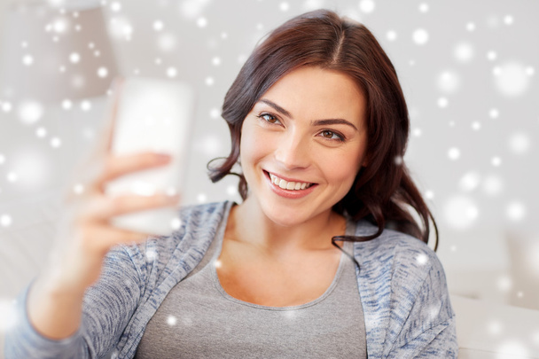 happy woman taking selfie with smartphone at home - Фото, зображення
