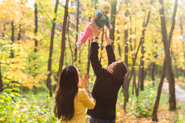Liebe, Elternschaft, Familie, Jahreszeit und Menschen-Konzept - lächelndes Paar mit Baby im Herbstpark - Foto, Bild