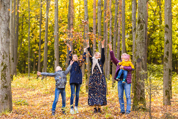 perhe, lapsuus, vuodenaika ja ihmiset käsite onnellinen perhe leikkii syksyn lehdet puistossa
 - Valokuva, kuva
