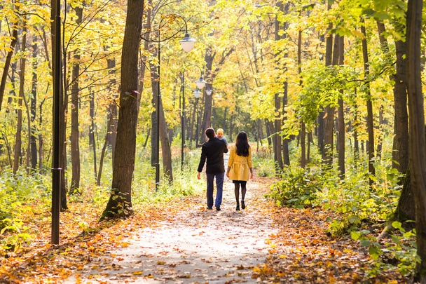 Joyeux jeune famille avec leur fille passer du temps en plein air dans le parc d'automne
 - Photo, image