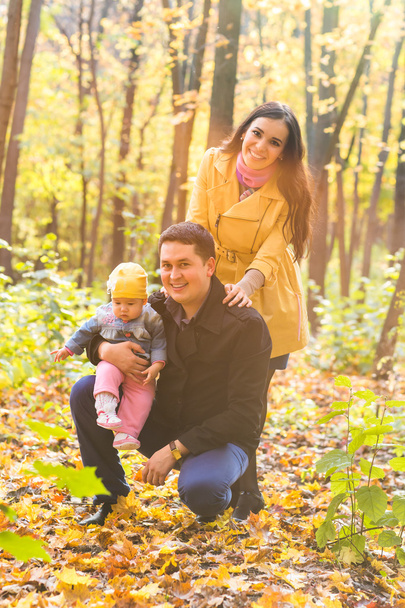 láska, rodičovství, Rodina, sezóna a lidé koncept - usmívající se pár s dítětem na podzim park - Fotografie, Obrázek