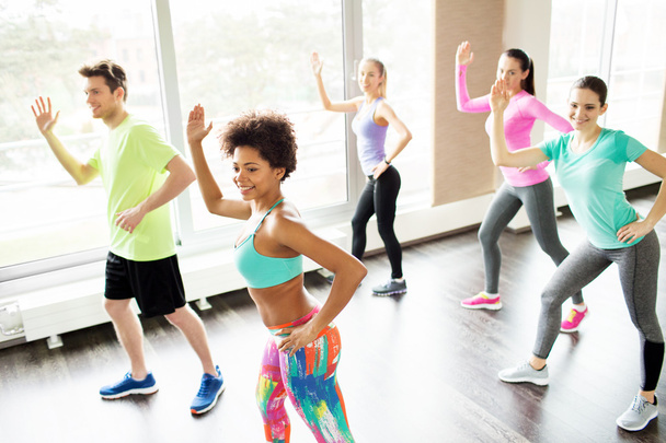 group of smiling people dancing in gym or studio - Foto, immagini