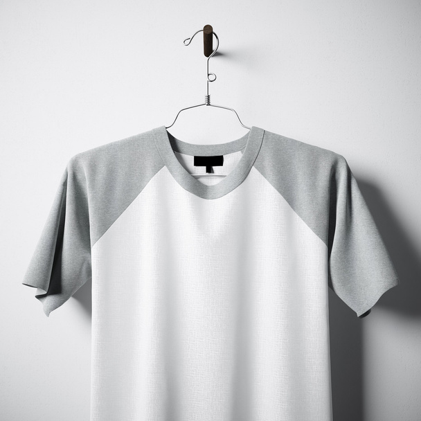 Closeup of blank white and gray cotton tshirt hanging in center empty concrete wall. Clear label mockup with highly detailed textured materials. Square. Front side view. 3D rendering. - Фото, изображение