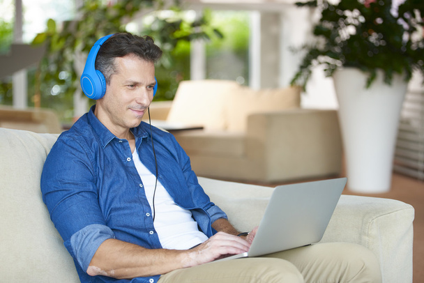 man with laptop and headphones at home  - Fotó, kép