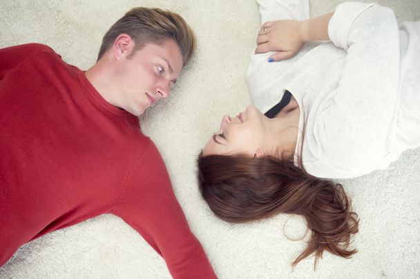 young couple on floor looking at each other - Fotoğraf, Görsel