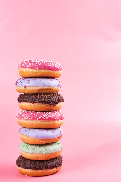 Sweet colorful tasty donuts on pink background.   - Photo, image