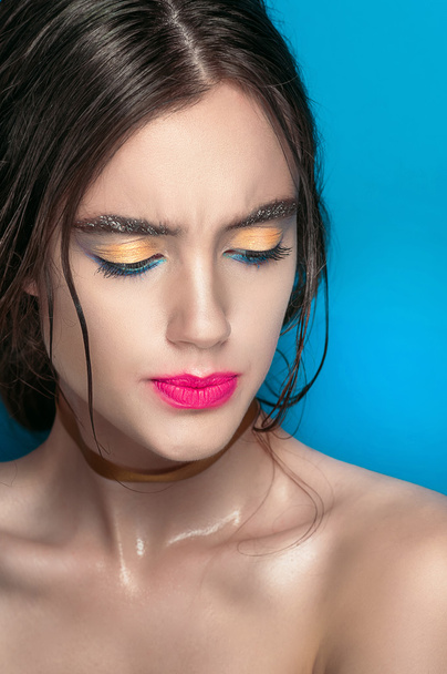 Beauty Girl Portrait with Vivid Makeup. Fashion Woman portrait close up on blue background. Bright Colors. Manicure Make up. Smoky eyes, long eyelashes. Rainbow Colors. Retouched shot - 写真・画像