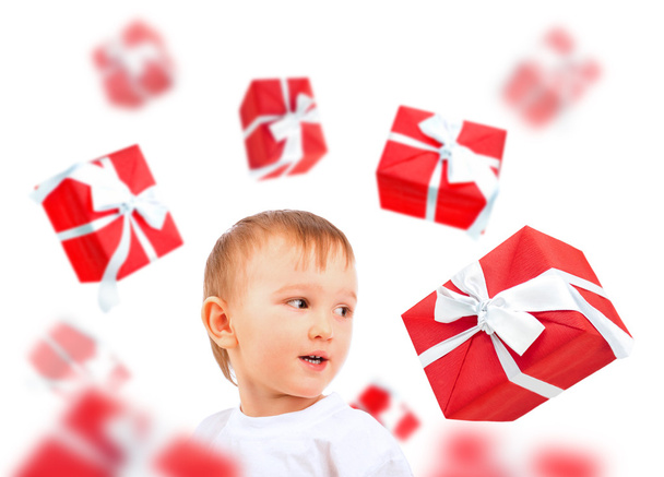 Little boy smiling and many gift boxes falling around him. Merry - 写真・画像