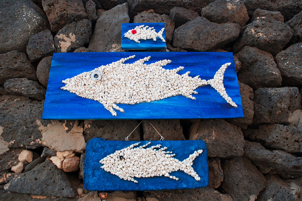 деревянные панели с рыбами, висящими на черных скалах
 - Фото, изображение