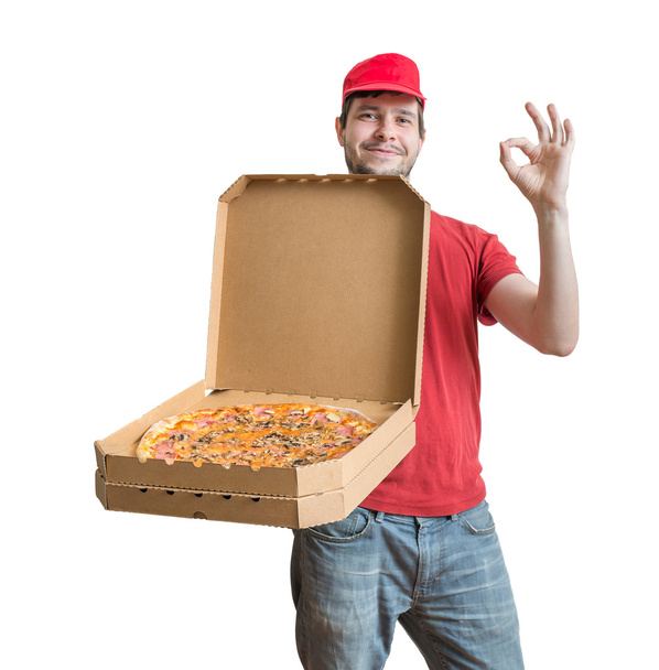 Pizza-Lieferkonzept. junger Mann hält geöffnete Schachtel mit Pizza in der Hand und zeigt sie. isoliert auf weißem Hintergrund. - Foto, Bild