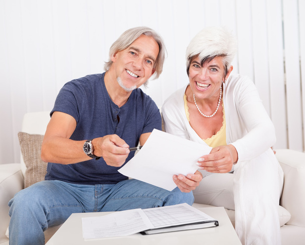 Excited middle-aged couple reading document - Photo, Image