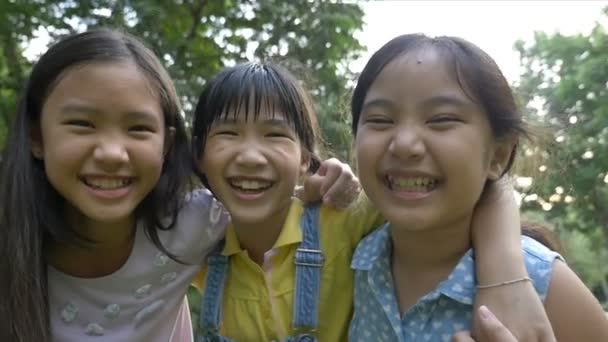 Zeitlupenaufnahme: Gruppe kleiner glücklicher asiatischer Mädchen spielt zusammen im Park - Filmmaterial, Video