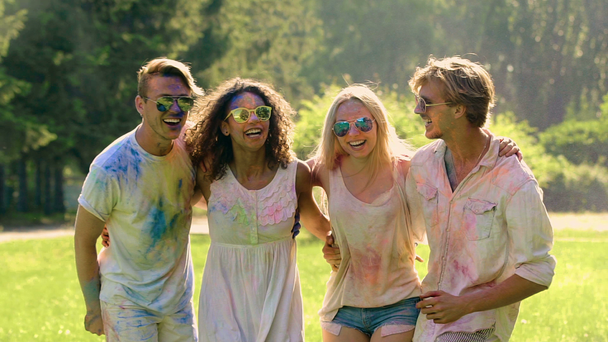 Щасливі молоді люди танцюють на фестивалі холі, кидали барвисті порошок в повітрі - Кадри, відео