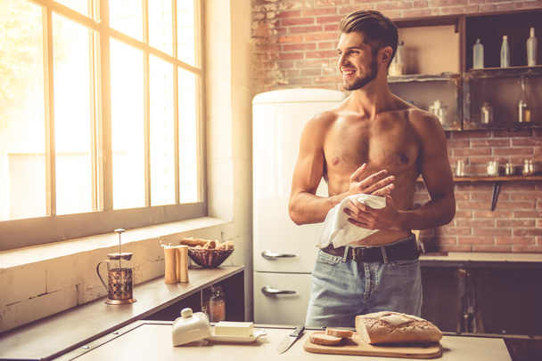 sexy jongeman in keuken - Foto, afbeelding