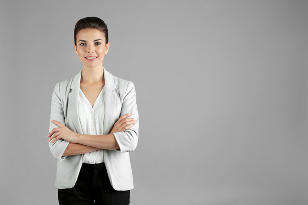 Beautiful businesswoman on gray background - Foto, imagen